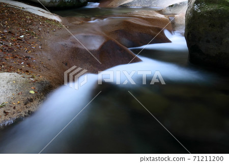 一條山stream,流過山谷的岩石表面 一條山stream,流過山谷的岩石表面 71211200