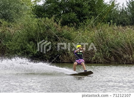 Teenager wakeboarding on a lake - Brwinow, Masovia, Poland 71212107