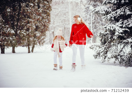 Mother and daughter in a winter park 71212439