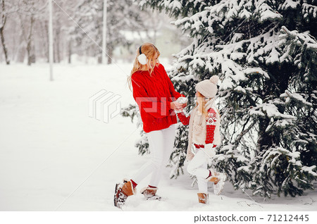Mother and daughter in a winter park 71212445