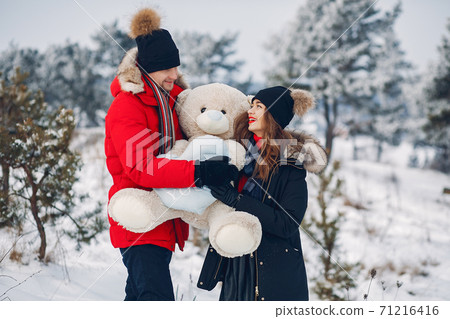 Loving couple walking in a winter park 71216416