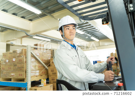 Male worker driving a forklift Male worker driving a forklift 71216602
