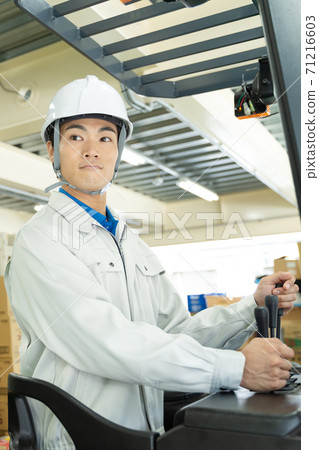Male worker driving a forklift 71216603