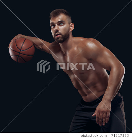 Portrait of a very muscular naked man playing basketball isolated on black background 71217353