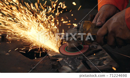 Professional mechanic is cutting steel metal. Professional mechanic is cutting steel metal. 71224698