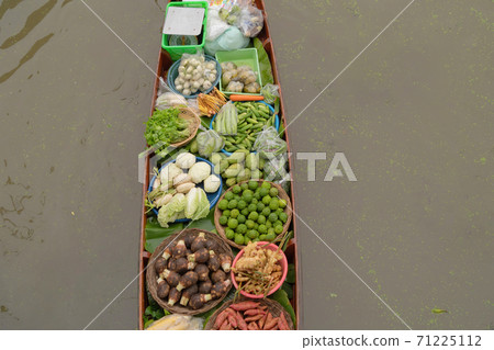 Damnoen Saduak Floating Market or Amphawa. Local people sell fruits, traditional food on boats in canal, Ratchaburi District, Thailand. Famous Asian tourist attraction. Damnoen Saduak Floating Market or Amphawa. Local people sell fruits, traditional food on boats in canal, Ratchaburi District, Thailand. Famous Asian tourist attraction. 71225112
