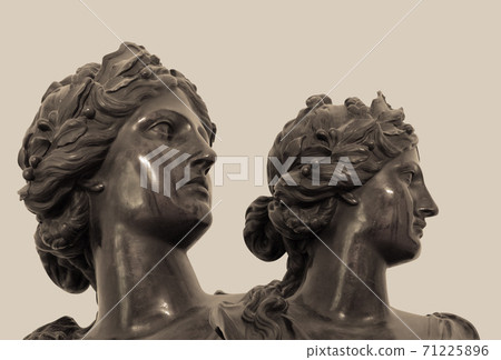 Gypsum copy of ancient statue heads on dark textured background. Plaster sculpture face 71225896