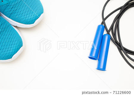 Flat lay with blue sneakers and blue Jumping rope. Gym equipment. Free space for text Flat lay with blue sneakers and blue Jumping rope. Gym equipment. Free space for text 71226600