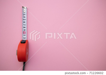 Industrial red measuring tape on pink background, top view. Free space for text 71226602