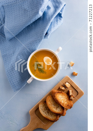 Bouillon, napkin and toasted bread on blue surface 71227213