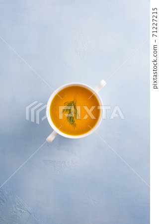 Bouillon with herb leaf in bowl on blue background Bouillon with herb leaf in bowl on blue background 71227215