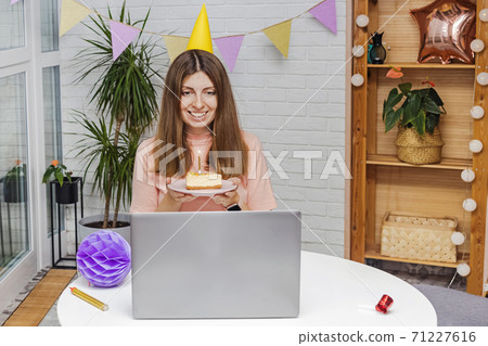 Woman celebrating her birthday at home and communicate with friends by video chat 71227616