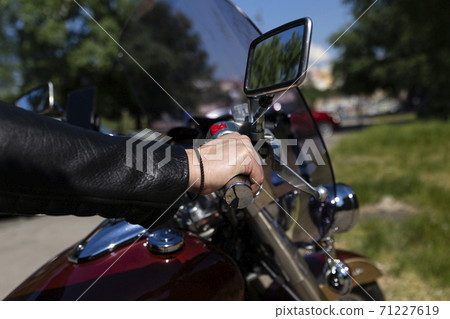 Biker riding on a motorcycle. View of a hand on handlebar giving gas 71227619