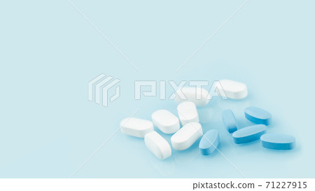 Several white and blue tablets or pills on the table. Medicine and pharmacy Several white and blue tablets or pills on the table. Medicine and pharmacy 71227915