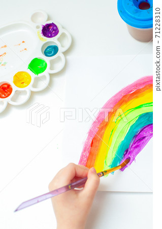 Kid painting rainbow during quarantine. 71228310
