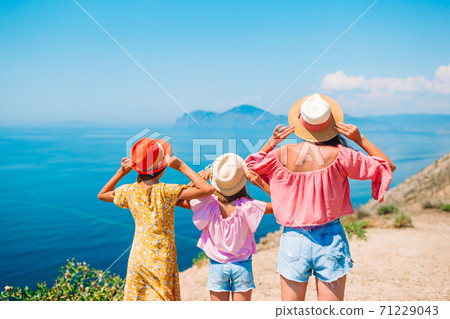 Adorable little girls and young mother on tropical white beach Adorable little girls and young mother on tropical white beach 71229043