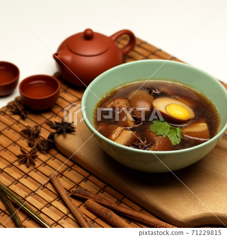 Sweet brown stewed eggs soup (Kai Palo) with pork on bamboo placemat, Thai food Sweet brown stewed eggs soup (Kai Palo) with pork on bamboo placemat, Thai food 71229815