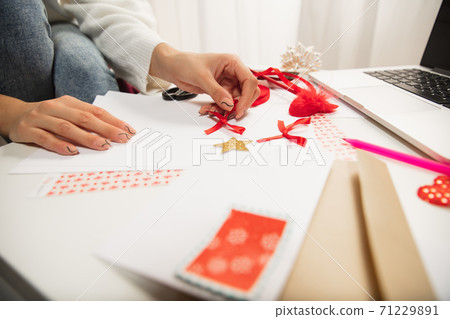 Woman making greeting card for New Year and Christmas 2021 for friends or family, scrap booking, DIY 71229891