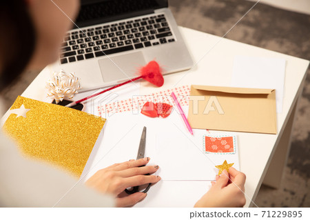 Woman making greeting card for New Year and Christmas 2021 for friends or family, scrap booking, DIY 71229895