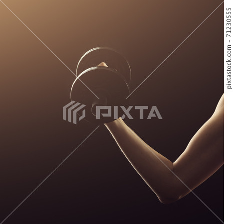 Slim athletic woman Holding dumbbell in the hand on black Slim athletic woman Holding dumbbell in the hand on black 71230555