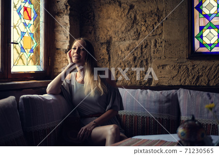 Portrait of young beautiful woman in asian restaurant sitting on the sofa 71230565