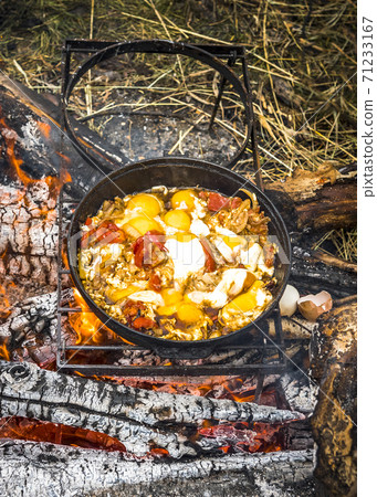 Omelet with tomatoes on an open fire in a tourist camp 71233167