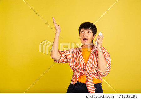 Senior woman isolated on yellow background. Tech and joyful elderly lifestyle concept Senior woman isolated on yellow background. Tech and joyful elderly lifestyle concept 71233195