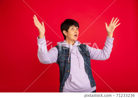 Senior woman isolated on red background. Tech and joyful elderly lifestyle concept Senior woman isolated on red background. Tech and joyful elderly lifestyle concept 71233236