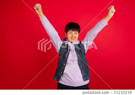 Senior woman isolated on red background. Tech and joyful elderly lifestyle concept 71233239