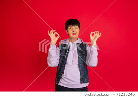 Senior woman isolated on red background. Tech and joyful elderly lifestyle concept Senior woman isolated on red background. Tech and joyful elderly lifestyle concept 71233240