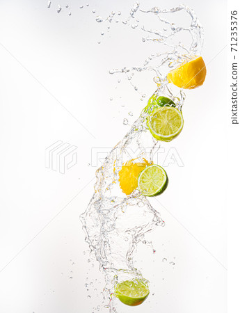 Fresh limes and lemons with water splash in midair, isolated on white background 71235376
