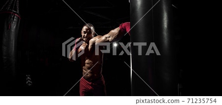 Thai boxer punch kick by punching bag Thai boxer punch kick by punching bag 71235754