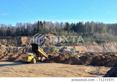 The work of heavy machinery and mining trucks in the open pit mine The work of heavy machinery and mining trucks in the open pit mine 71235975