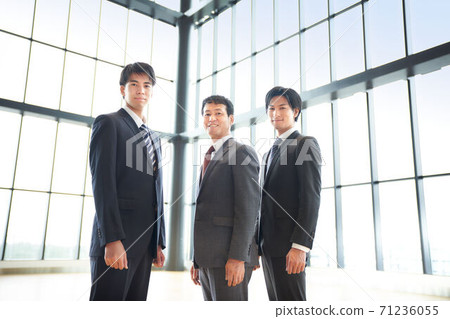 Three businessmen standing side by side Three businessmen standing side by side 71236055