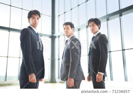 Three businessmen standing side by side Three businessmen standing side by side 71236057