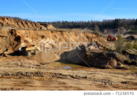 Big yellow mining truck transporting sand in an open-pit mining quarry - image Big yellow mining truck transporting sand in an open-pit mining quarry - image 71236570