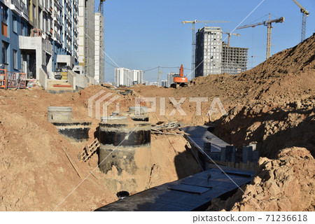 Laying concrete manholes and heating drain pipes and for stormwater system at construction site Laying concrete manholes and heating drain pipes and for stormwater system at construction site 71236618