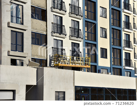 Suspended construction cradle on the background facade of the building.  71236620