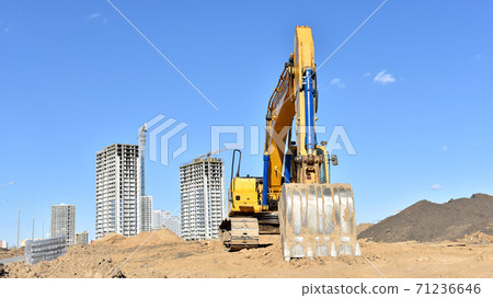 Excavator working at construction site on earthworks. Excavator working at construction site on earthworks. 71236646