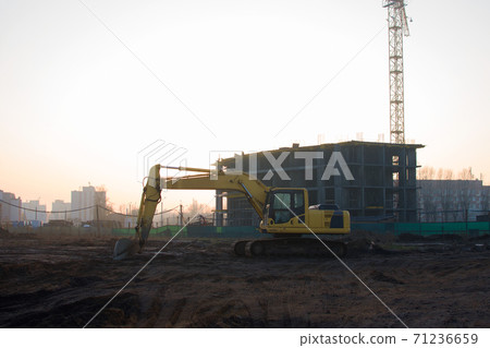 Excavator at construction site on a background of a construction cranes and building.  71236659