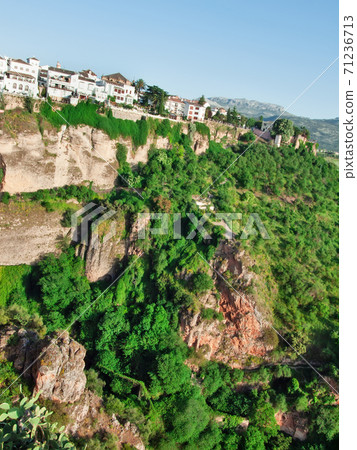 Panoramic view at gorge with houses of New bridge in Ronda, one of the famous place in Andalucia. Andalusia, Spain Panoramic view at gorge with houses of New bridge in Ronda, one of the famous place in Andalucia. Andalusia, Spain 71236713