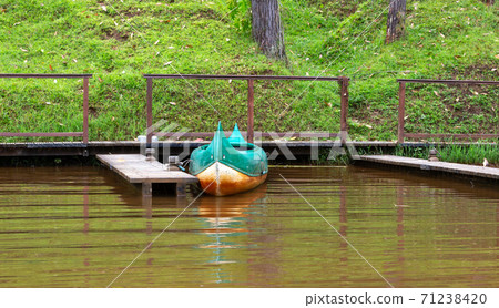 A boat on a lake is parked on a jetty 71238420