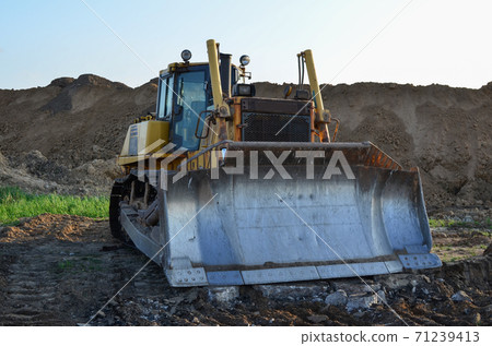 Bulldozer with bucket for pool excavation and utility trenching. Dozer during demolition concrete  71239413