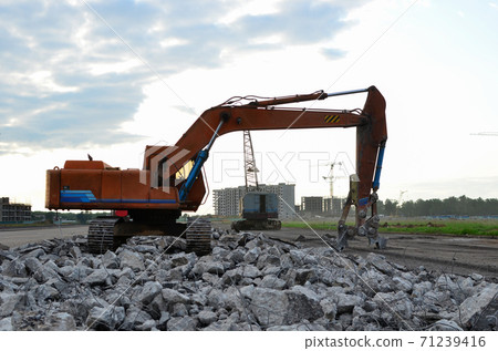 Excavator with hydraulic shears for cutting and crumbles demolition concrete construction site. Excavator with hydraulic shears for cutting and crumbles demolition concrete construction site. 71239416