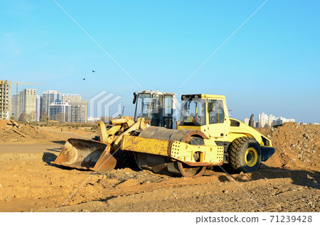 Soil Compactor and wheel loader at construction site.  71239428