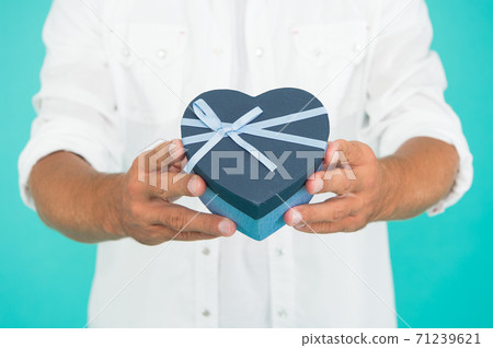 secret attraction. man hold heart gift box. present with love 71239621