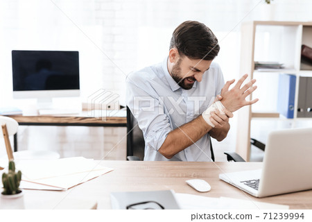 Man suffers and hold on to a sore wrist at work. Man suffers and hold on to a sore wrist at work. 71239994