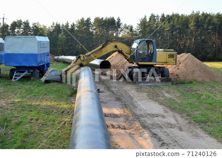 Excavator digs ground for the installation of industrial gas and oil pipes. Natural gas pipeline  71240126