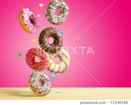 Flying donuts. Mix of multicolored sweet doughnuts with sprinkel on pink background falling on the table. 71240596