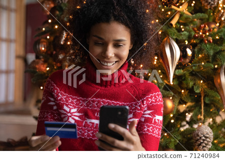 Close up African American woman paying online for Christmas gifts Close up African American woman paying online for Christmas gifts 71240984